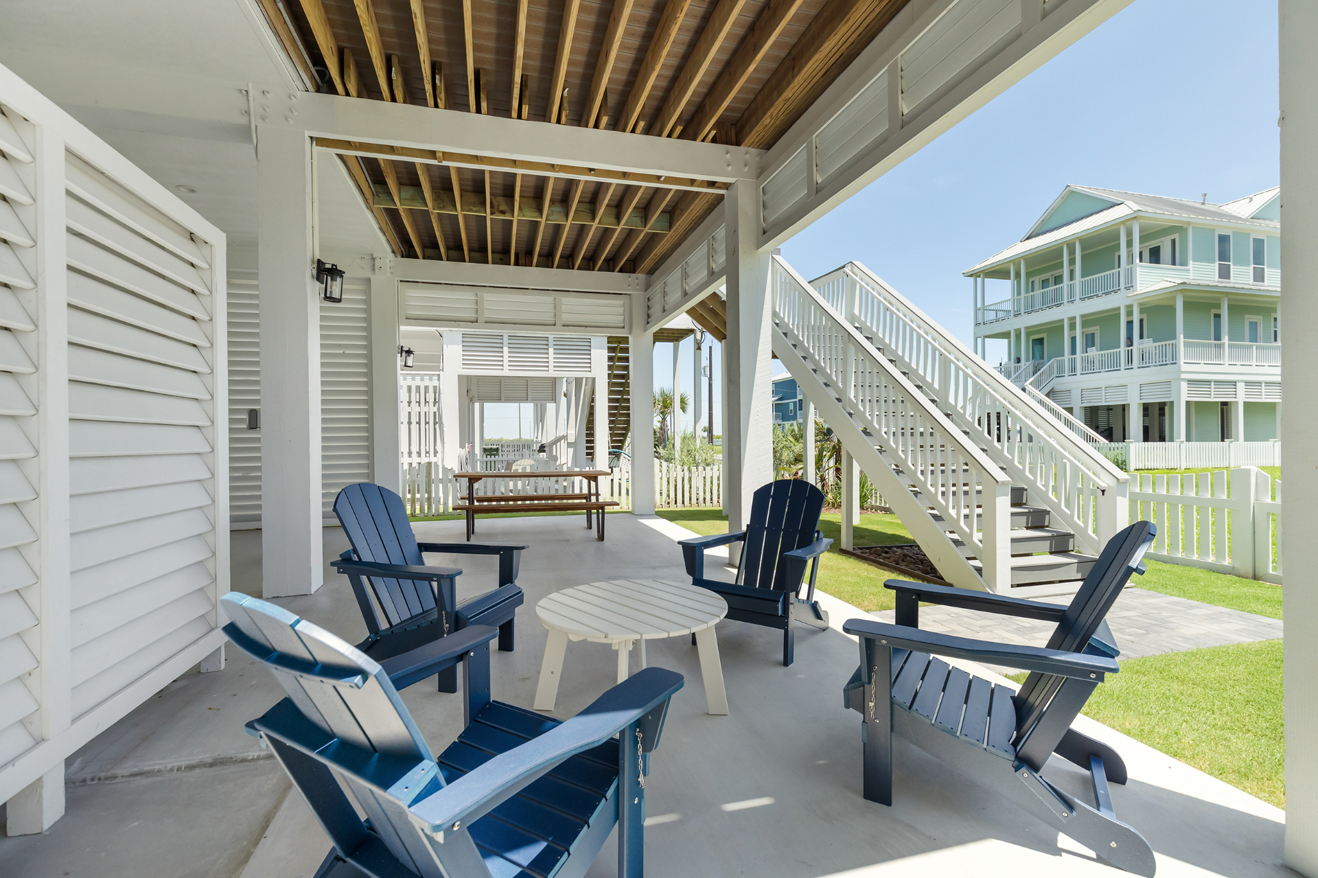 Covered patio with navy Adirondack chairs at Serenity Cove